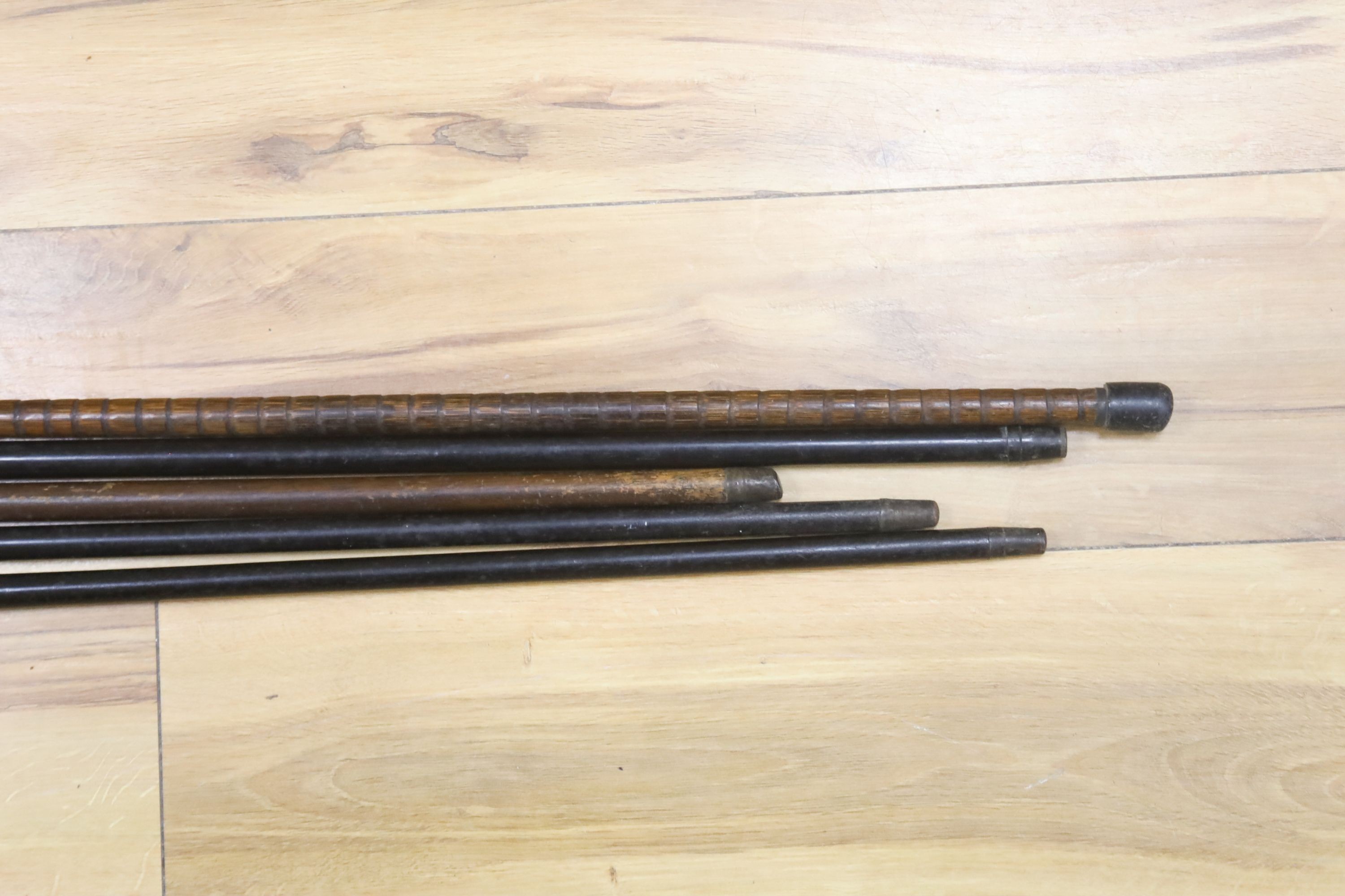A 9ct gold mounted walking stick, three silver-topped sticks and another